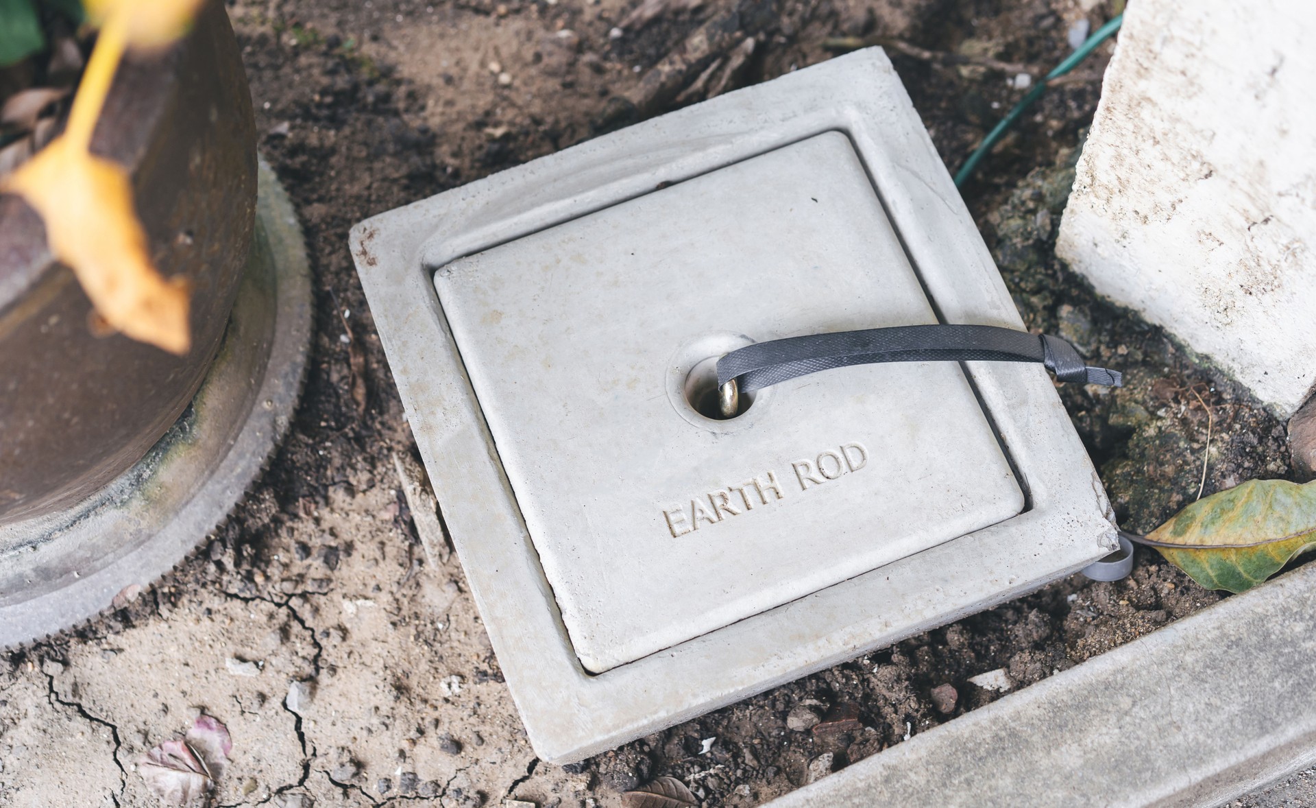 Block of cement with ground wire or earth rod in soil protect electric system from thunder