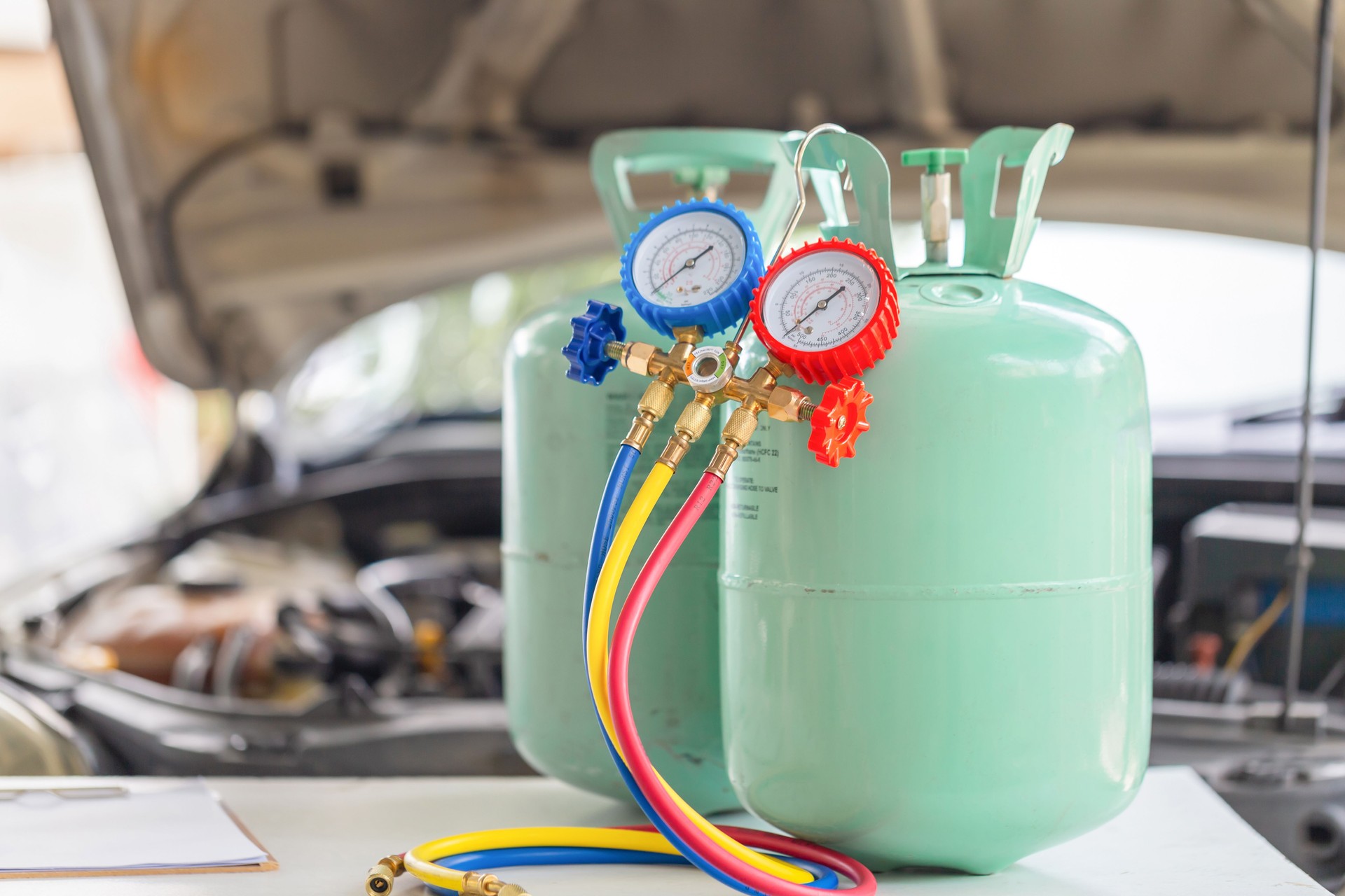 Manifold tool gauge bucket refrigerant applies to car air conditioning with blurred technician repairman check car air conditioning system refrigerant recharge, Car Air Conditioning Repair